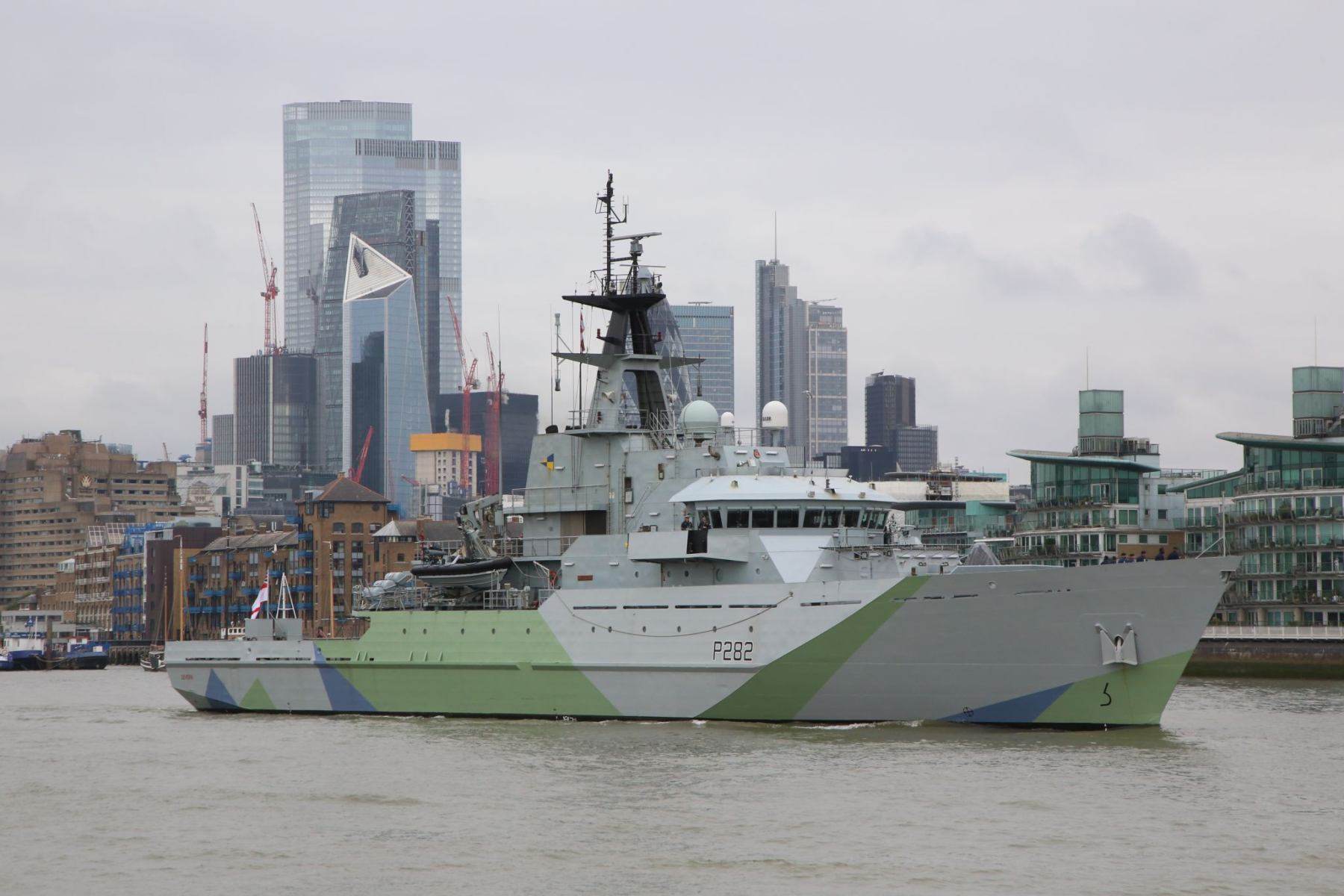 Royal Navy P282 HMS Severn leaving London sailing down the River Thames in Western Approaches camouflage on  11-Sep-2021, City of London in background.