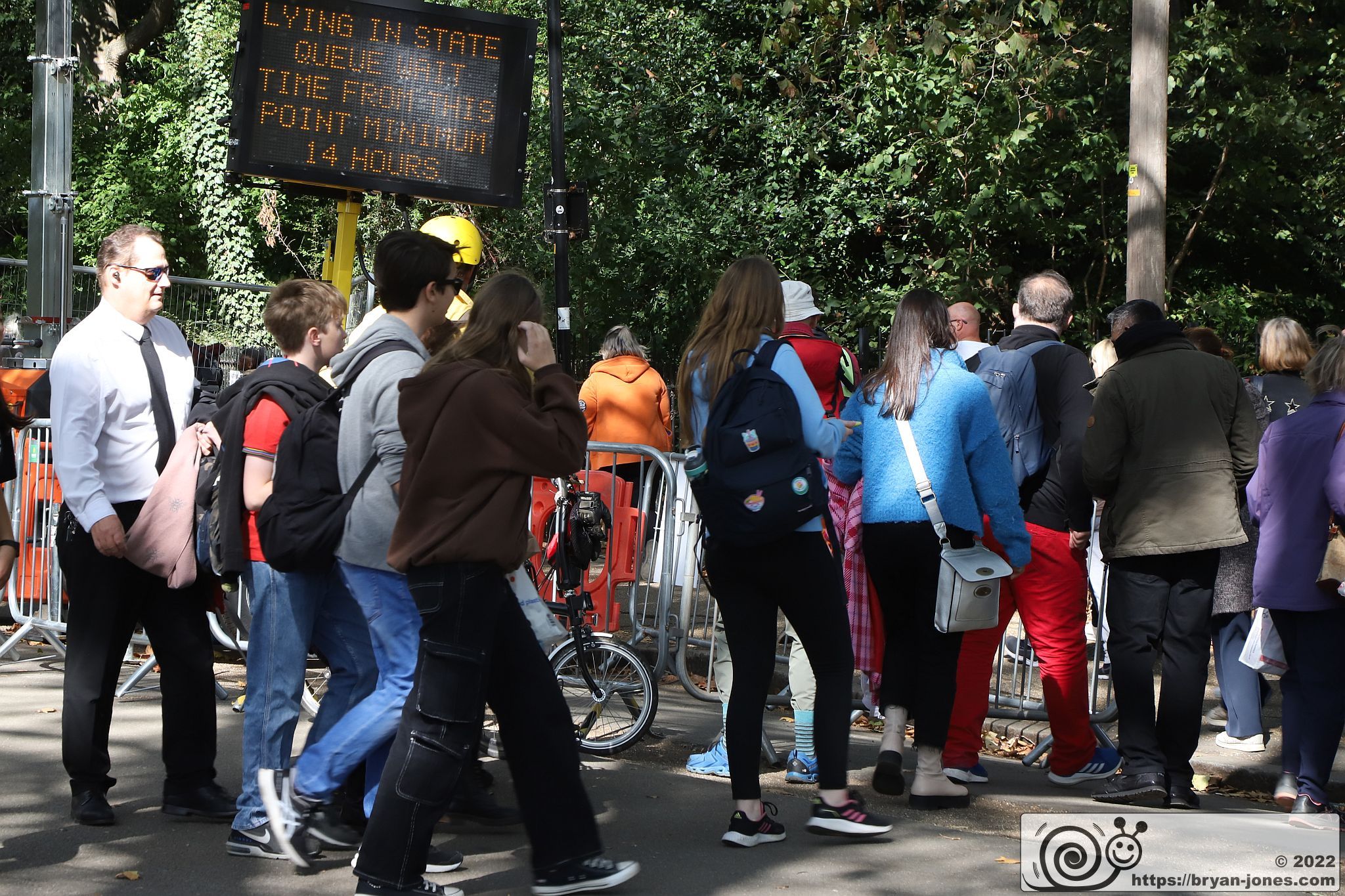 Mourners enter the queue with electronic sign showing wait time