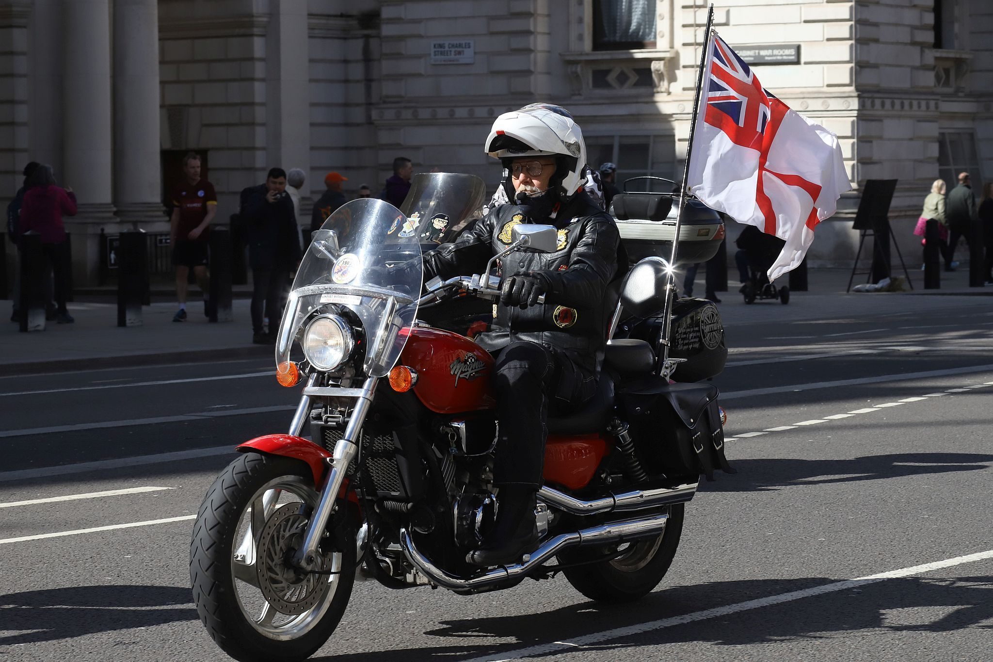 The Rolling Thunder UK military veterans motorcycle Ride of Respect, in memory of the late HM Queen Elizabeth II. 7th April 2023, Good Friday. Photographed in Whitehall, Westminster, London passing The Cenotaph war memorial and 10 Downing Street. Armed forces veterans. Royal Navy White Ensign flag.