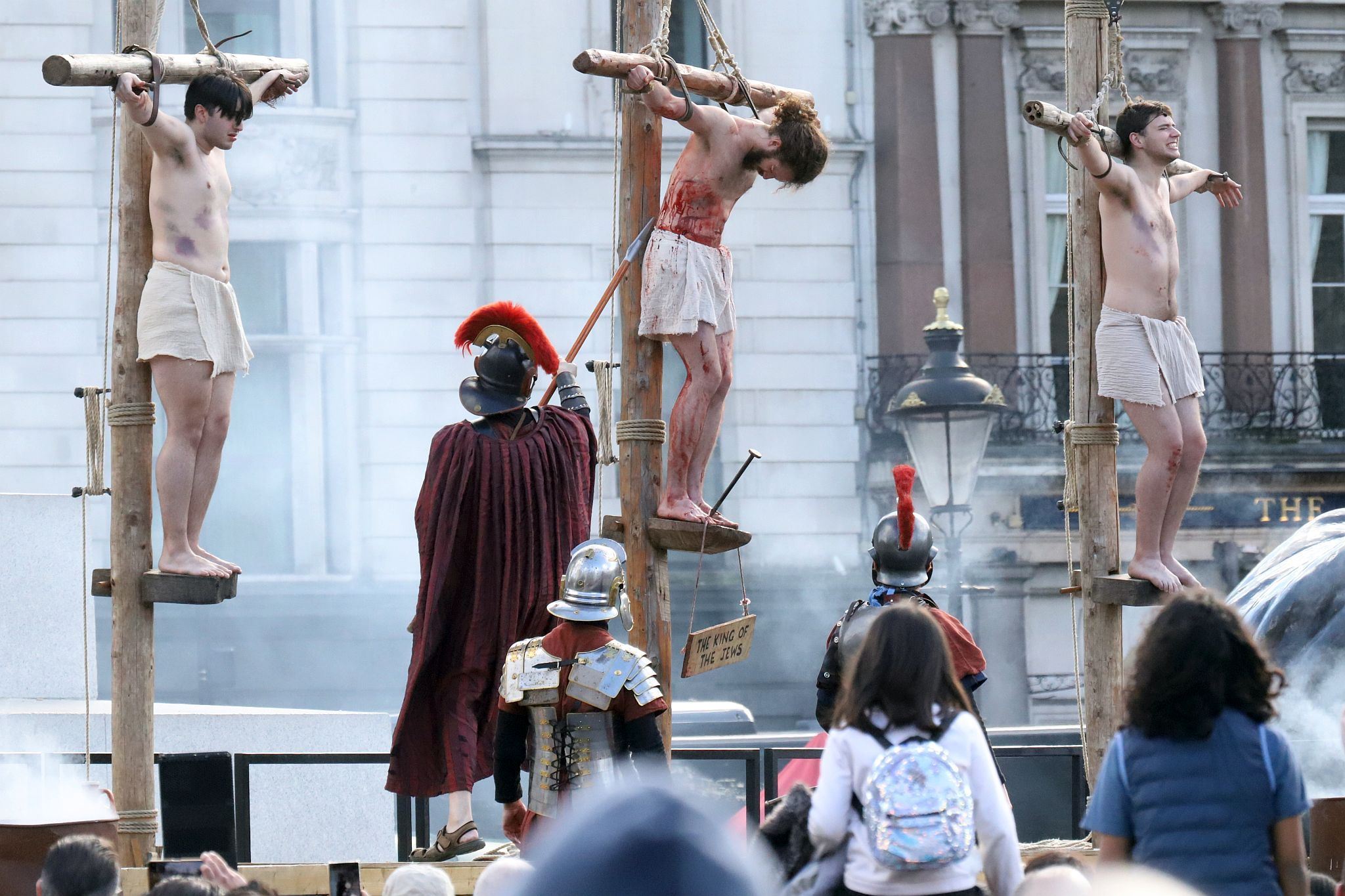 The Good Friday Wintershall Easter Passion Play "The Passion of Jesus" presented at Trafalgar Square in London. 7th April 2023. A Roman soldier stabs Christ with a spear whilst he is still on the cross to ensure that he is dead.
