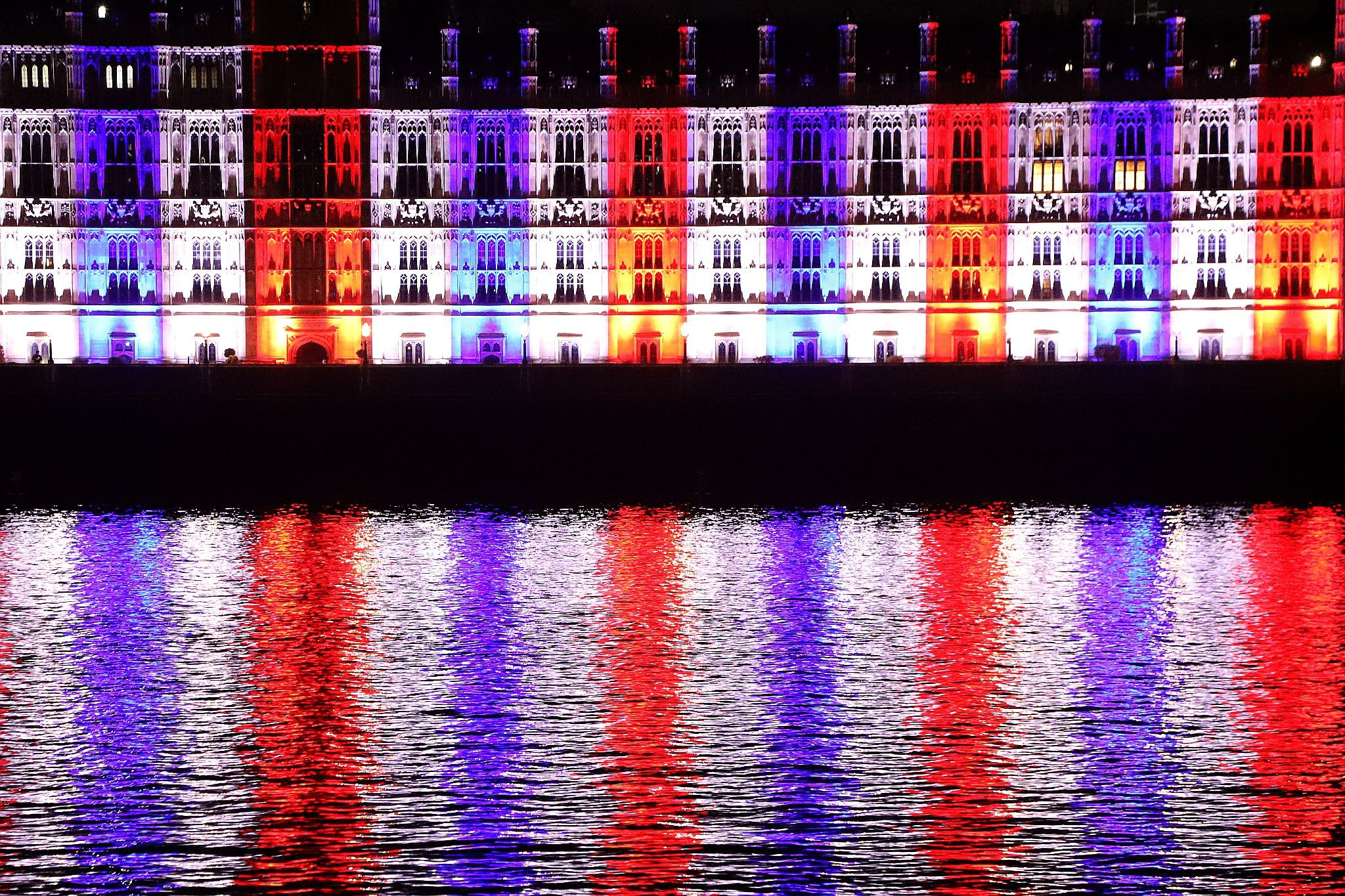 The Houses of Parliament lit red, white and blue to mark the Coronation of King Charles III and Queen Camilla. Photo taken 07-May-2023. London.
