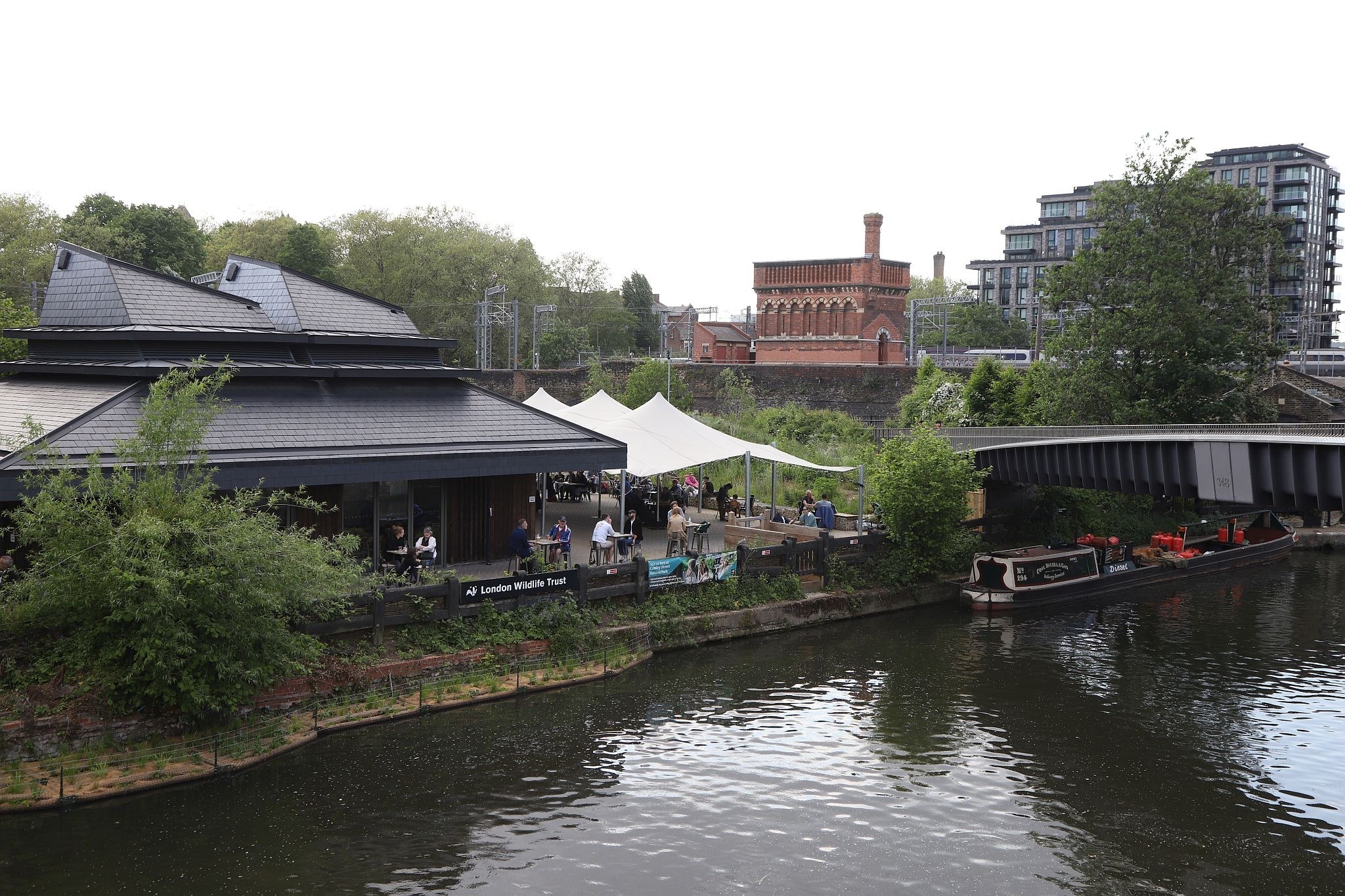 Looking across the Somers Town bridge, crossing the Regent's Canal, to the St Pancras waterpoint. Water tower. King's Cross. Coal Drops Yard. Regents Canal. 20-May-2023.