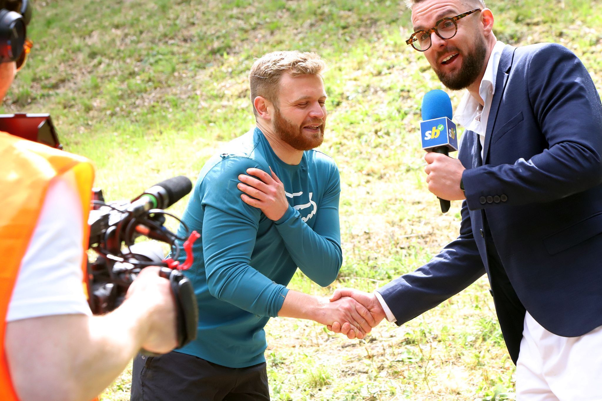 TV/Film crew interviewing a winner. Coopers Hill Cheese Rolling Race. 29-May-2023. Race downhill. Gloucestershire tradition.