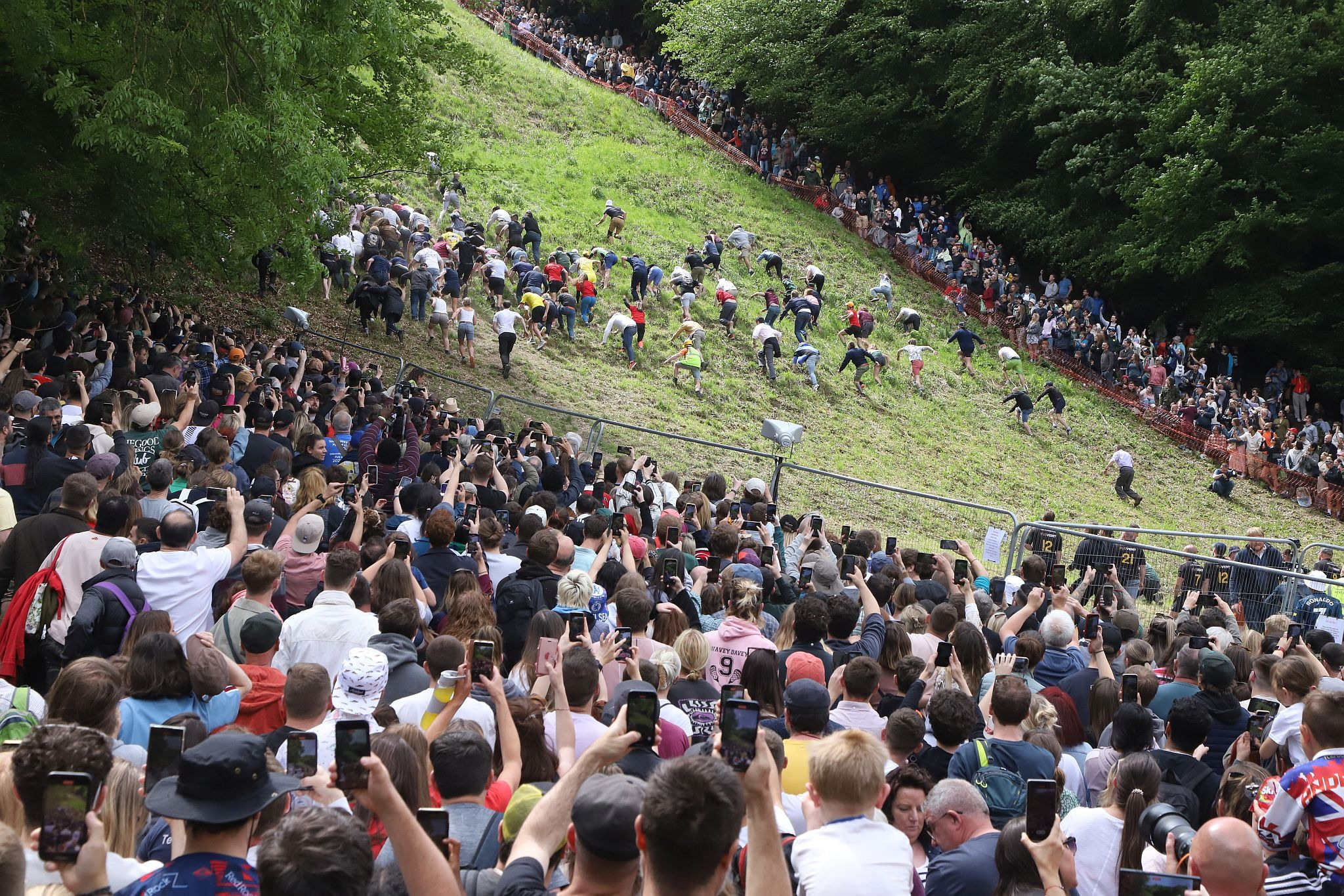 Uphill race watched by a huge crowd. Coopers Hill Cheese Rolling Race. 29-May-2023. Race downhill. Gloucestershire tradition.