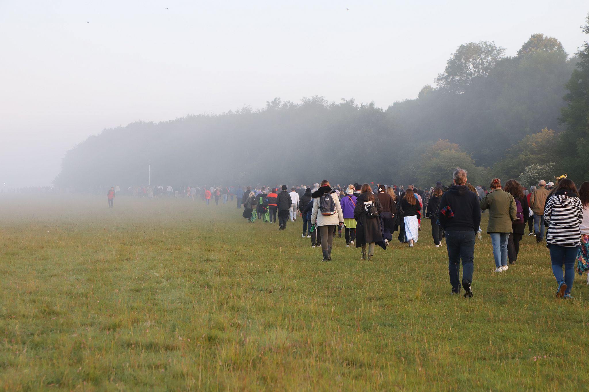 The crowd heading back to the Visitors Centre after dawn. The 2023 Summer Solstice longest day at Stonehenge in Wiltshire, UK. Photo taken 21-Jun-2023.