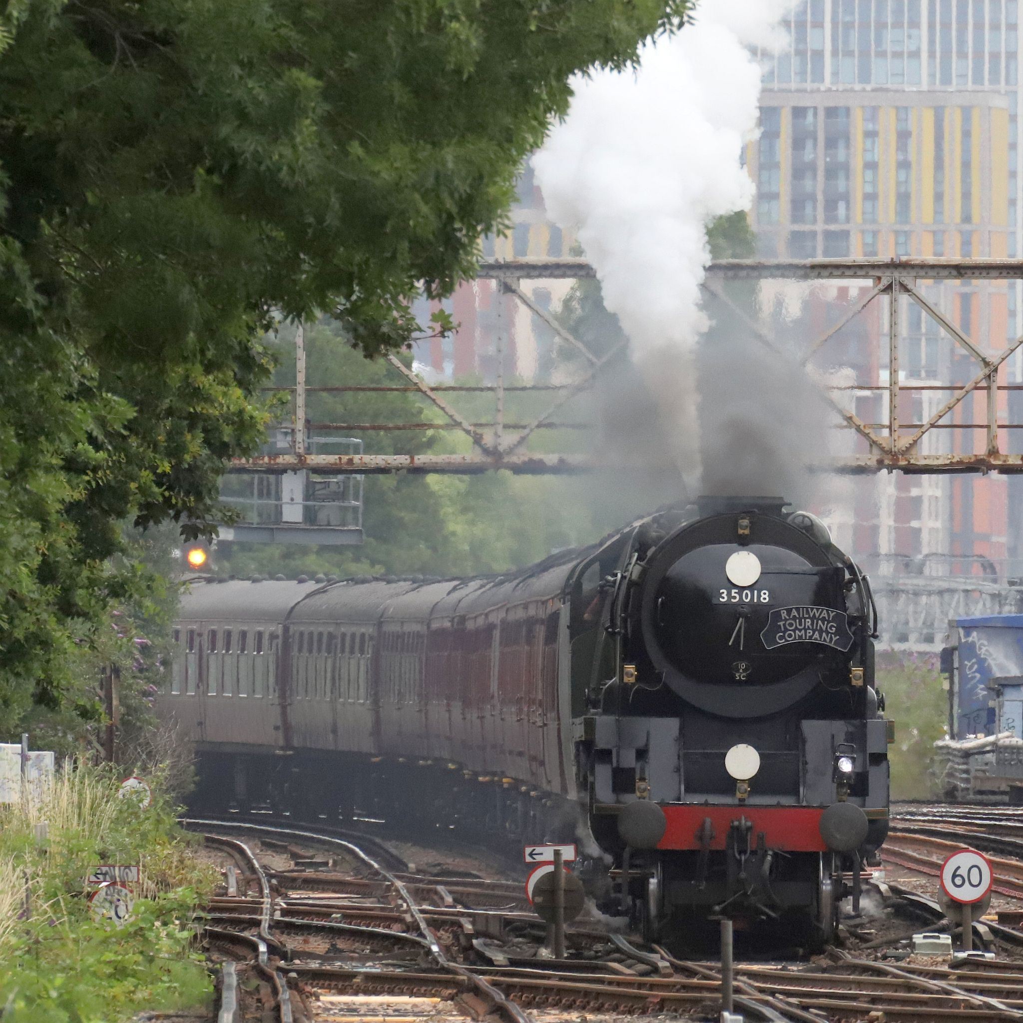 On Sunday 9th July 2023, Southern Railway Merchant Navy Pacific steam engine 35018 "British India Line", slows to negotiate the trackwork at Clapham Junction having climbed up the line from London Victoria at 09:23 running 18 minutes late.