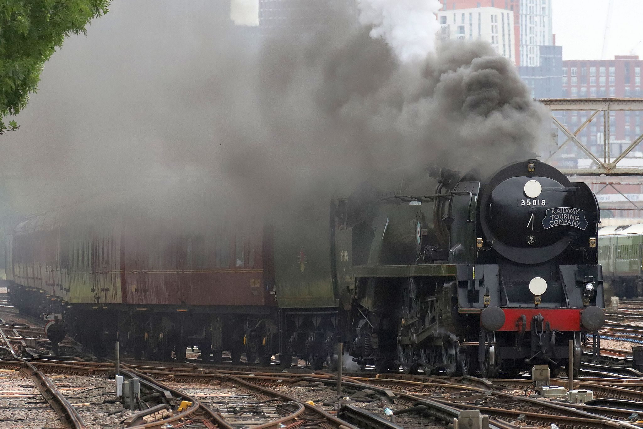 On Sunday 9th July 2023, Southern Railway Merchant Navy Pacific steam engine 35018 "British India Line", slows to negotiate the trackwork at Clapham Junction having climbed up the line from London Victoria at 09:23 running 18 minutes late.