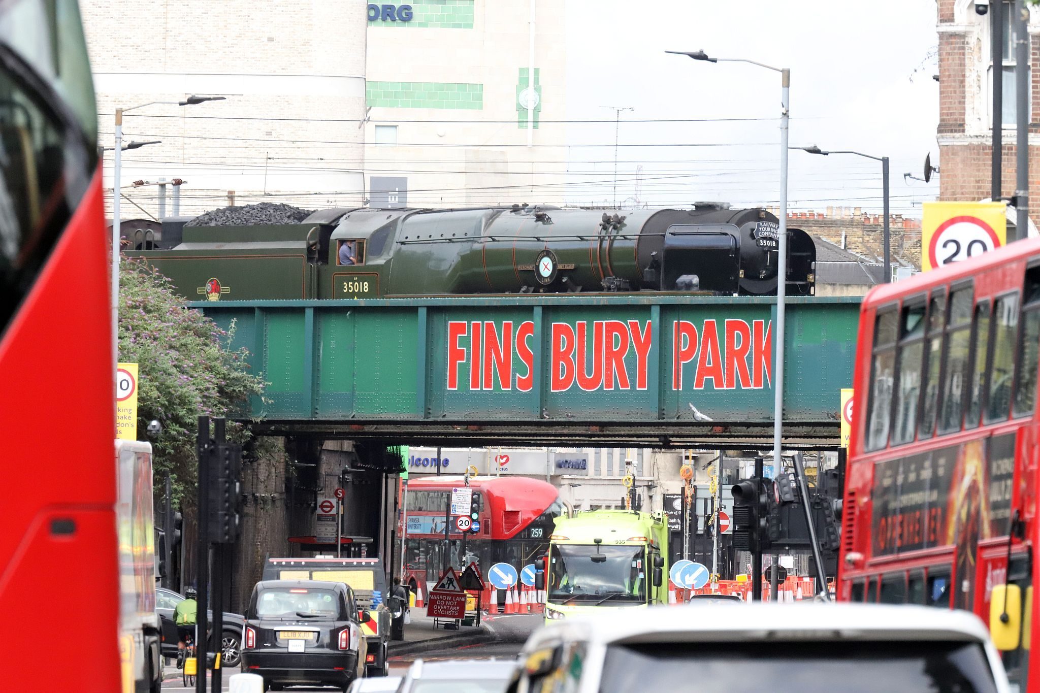 Southern Railway Merchant Navy Pacific 35018 "British India Line", passing through Finsbury Park station in North London on 15th July 2023, working the Railway Touring Company "White Rose" special train from London Kings Cross to York.  The picture on the bridge was taken at 06:56 as the train crossed Seven Sisters Road via platform 1 on its way to Kings Cross for the passengers to board. 35018 was on the rear going backwards so as to be at the right end to pull the train from Kings Cross to York.