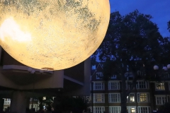 Looking to the homes in Campden Hill Road. Luke Jerram's "Mars: War and Peace" on display in Jubilee Square outside Kensington and Chelsea Town Hall, and the Central Library. Mars was on display as part of the 2023 Kensington and Chelsea Festival. Photo taken 11-Aug-2023. https://bryan-jones.com