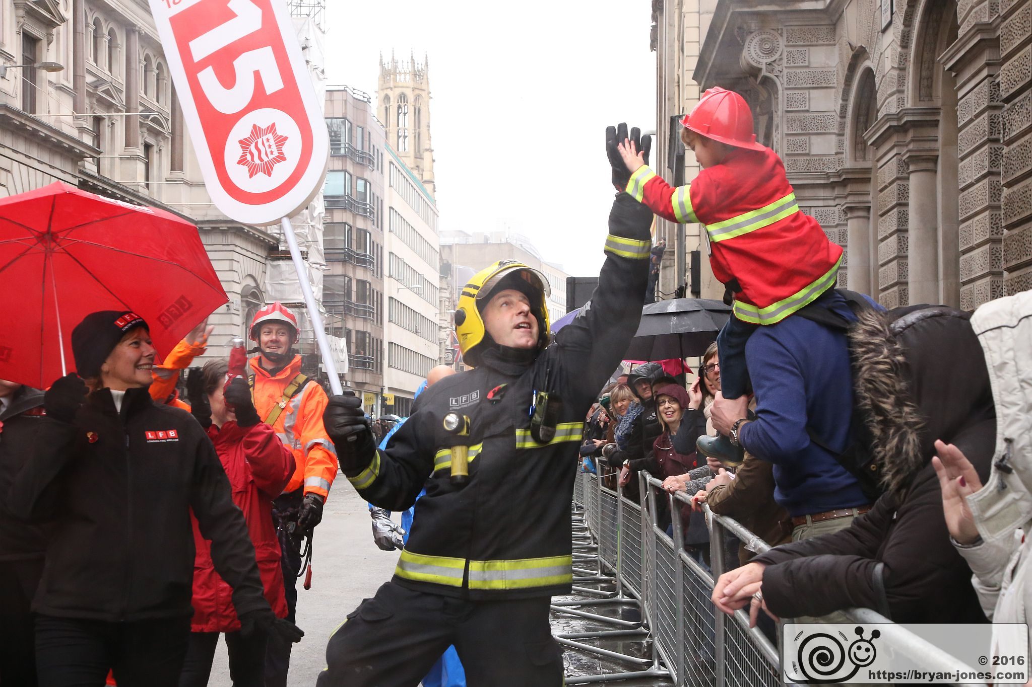 LFB firefighter and child high five at the 2016 Lord Mayor's Show. This is the original image used for the LFB150 photo mosaic