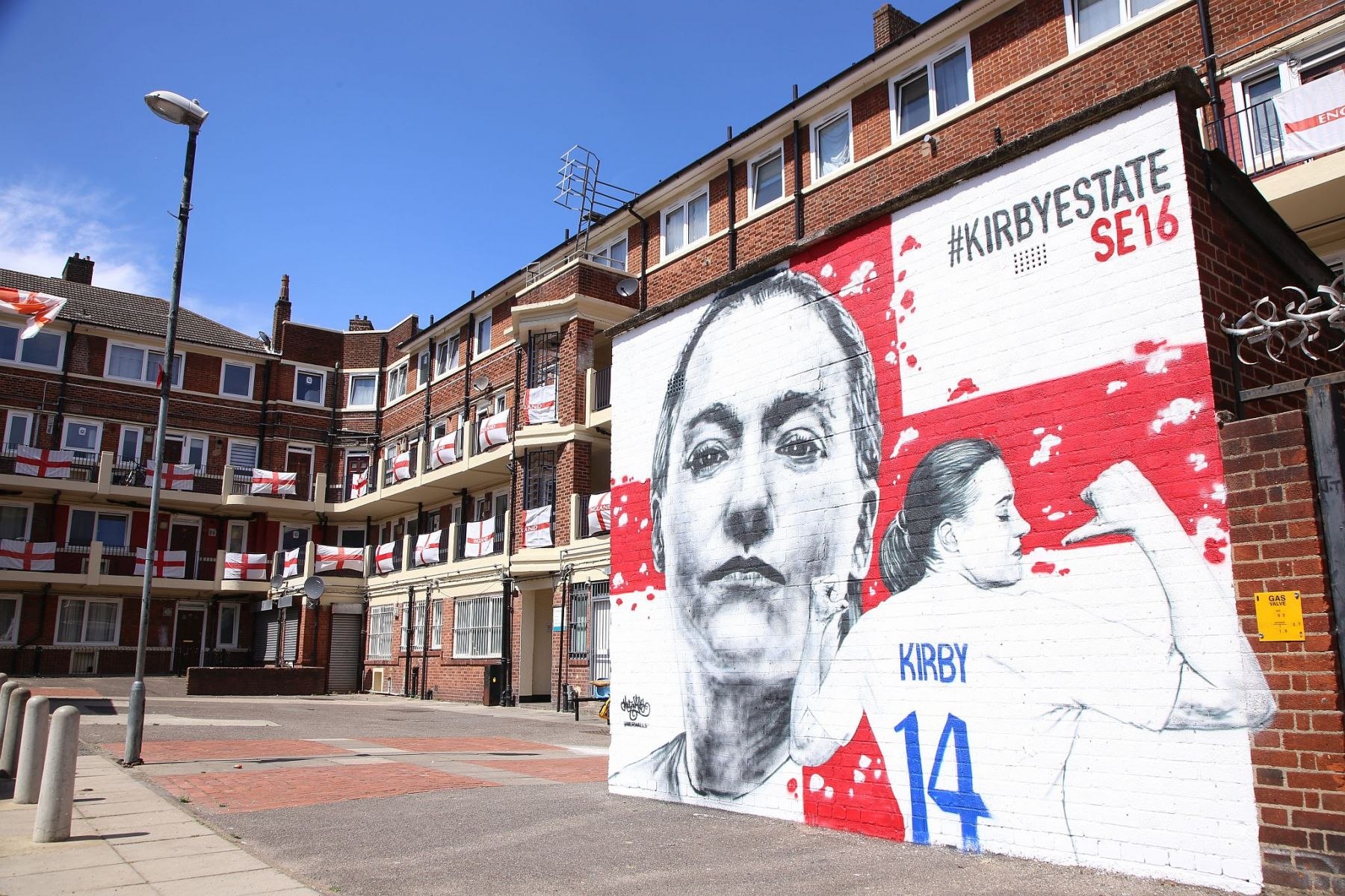 Spray painted mural of footballer Fran Kirby at the Kirby Estate (Bermondsey SE London) with England flags flying from the flat's balconies