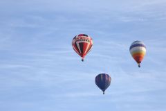 A flight of 46 hot air balloons taking part in the 2019 Lord Mayor’s Balloon Regatta fly over Greenwich passing the Cutty Sark ship and Old Royal Navy College by the River Thames early on the morning of  09-Jun-2019. City of London.