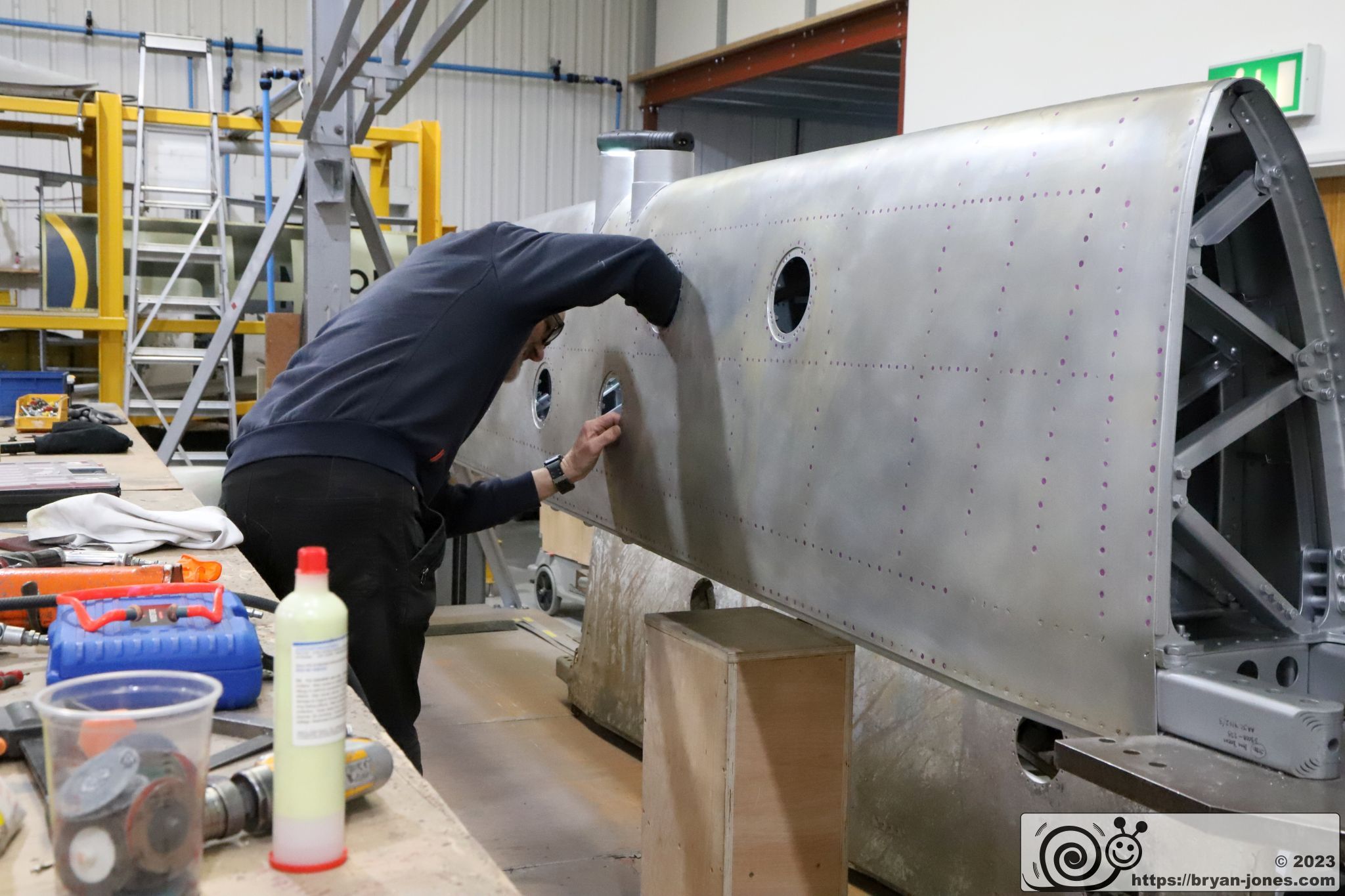 Engineer working on wing from Spitfire Mk IX MA764 in a jig